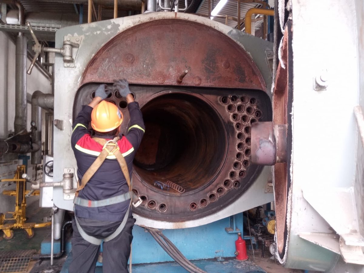 Teknisi PT Dirani Tech Ekatama memakai full body harness saat membuka pintu depan boiler