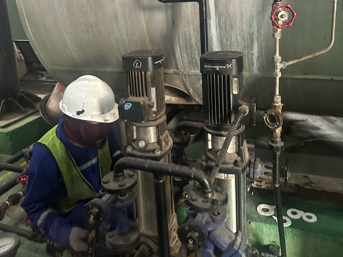Teknisi memeriksa pompa air umpan boiler